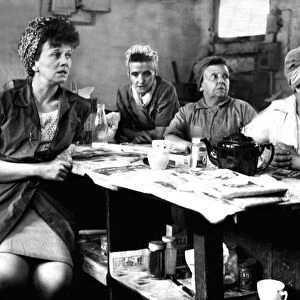 Four buffer girls, wives of Yorkshire miners, are having a cup of tea at their Sheffield