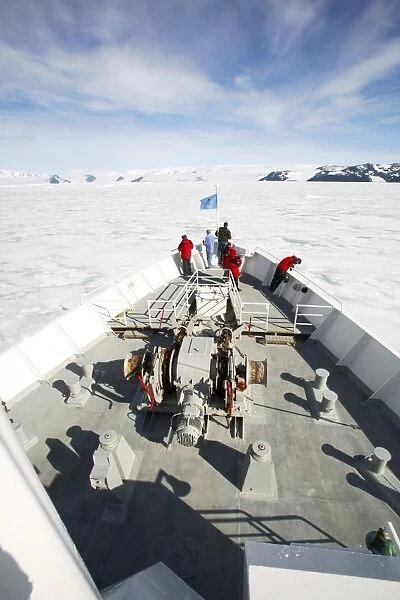 The National Geographic Endeavour breaking through fast ice in the Weddell Sea around the Antarctic Peninsula. Guests are on the bow watching the process