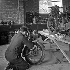 Two men repairing motorcycles