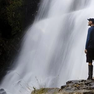 A hiker enjoys Fergusson Falls on the Overland Track