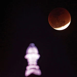 A lunar eclipse of a full Blue Moon is seen over the building of Indias Ministry of