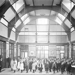 Interior of Hammerton Street School, Darnall, 1904, showing children and teachers with the inscription on the back wall, Let knowledge grow from more to more