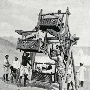 Arabian children enjoying a big-wheel, 1922