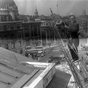 Herbert Morrison, Minister of Home Security, up a ladder, London. 1942
